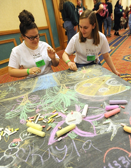 St.Vincent DePaul of Niagara Falls students Hannah Hrotko, 14, and Diega Ciraolo, 16, write inspiring messages on one of many chalk tables. (Dan Cappellazzo/Staff Photographer)